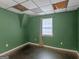 A simple bedroom featuring green walls, a window and a dark brown floor at 140 Joshua St, Palmetto, GA 30268
