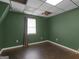 A simple bedroom featuring green walls, a window and a dark brown floor at 140 Joshua St, Palmetto, GA 30268
