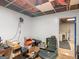 An unfinished hobby room with boxes, bins, and an exposed ceiling awaits renovation at 140 Joshua St, Palmetto, GA 30268