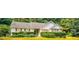 Charming single-story home featuring mature landscaping, white siding, and a stone accent wall at 60 Doe Run Dr, Sharpsburg, GA 30277