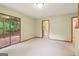 Open living space with neutral carpet and sliding glass door leading to the outdoor deck at 497 Fire Fly Dr, Tucker, GA 30084