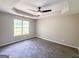 A modern bedroom with tray ceilings, a ceiling fan, and a window to the outside at 530 Austin Dr, Mcdonough, GA 30252