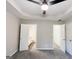 A modern bedroom with tray ceilings, a ceiling fan, and doorways to the bathroom and closet at 530 Austin Dr, Mcdonough, GA 30252