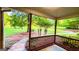 Inviting covered porch with wood railing overlooks a large grassy yard surrounded by mature trees at 530 Austin Dr, Mcdonough, GA 30252