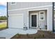 Close up of townhome entrance and garage featuring black door and welcome sign at 109 Feeney Lane, Villa Rica, GA 30180