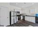 Modern kitchen featuring stainless steel appliances, white cabinets, and laminate floors at 109 Feeney Lane, Villa Rica, GA 30180
