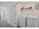 Functional laundry room featuring a washer, dryer, and shelving for storage at 109 Feeney Lane, Villa Rica, GA 30180