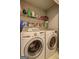 Functional laundry area with a washer, a dryer, and shelving for storage at 254 Roberts Trl, Locust Grove, GA 30248