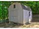 White backyard shed near a lake surrounded by trees and greenery at 254 Roberts Trl, Locust Grove, GA 30248