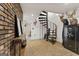 Finished basement showcasing spiral staircase and brick accent wall, adding unique character to the space at 405 Miller Rd, Covington, GA 30014