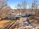 Waterfront home with carport, deck, and mature trees under a clear blue sky at 405 Miller Rd, Covington, GA 30014