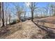 A back view of this home featuring a long porch, a carport, and mature trees at 405 Miller Rd, Covington, GA 30014