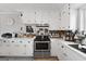 Bright kitchen featuring white cabinets, stainless steel oven, and modern fixtures at 405 Miller Rd, Covington, GA 30014