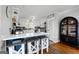 Kitchen with island, white cabinets, wooden stools, and stainless steel appliances at 405 Miller Rd, Covington, GA 30014