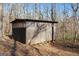 A side angle view of a tall dark-colored shed with a door and a window at 405 Miller Rd, Covington, GA 30014