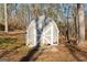 The white-trimmed shed has a decorative door, is located at ground level, and needs some repairs at 405 Miller Rd, Covington, GA 30014