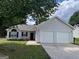 Charming single-story home featuring a two-car garage, tidy landscaping, and a welcoming entrance at 3081 Regal Dr, Mcdonough, GA 30253