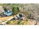 Aerial view highlighting a brick home's roof, driveway, and surrounding trees in a residential area at 418 Crosshaven Way, Mcdonough, GA 30253