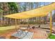 Backyard with a patio, shade sail, outdoor seating, and a built-in fire pit area at 418 Crosshaven Way, Mcdonough, GA 30253