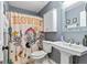 Stylish bathroom featuring a pedestal sink, cabinet, and unique themed shower curtain at 418 Crosshaven Way, Mcdonough, GA 30253