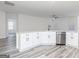 Open kitchen with stainless steel dishwasher and large granite breakfast bar with white cabinetry at 3382 Arabian Farm Ln, Dacula, GA 30019