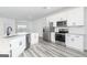 Bright kitchen boasts stainless appliances, white cabinets, granite countertops, and wood-look flooring at 3382 Arabian Farm Ln, Dacula, GA 30019