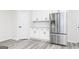 Sleek kitchen featuring stainless steel refrigerator, white cabinets, granite countertops, and modern hardware at 3734 Saddle Bag Ct, Dacula, GA 30019