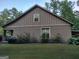 Home exterior view with brick foundation and landscaping at 57 Deer Creek Run, Moreland, GA 30259