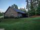 Charming home with lush green lawn, flowering bushes and wooded backdrop at 57 Deer Creek Run, Moreland, GA 30259