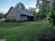 Well-maintained property with vibrant green lawn, flowering bushes and wooded backdrop at 57 Deer Creek Run, Moreland, GA 30259