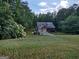 View of home from across expansive front lawn, with mature landscaping and mature trees at 57 Deer Creek Run, Moreland, GA 30259