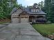 Charming home featuring a two-car garage, stone accents, covered porch and established landscaping at 57 Deer Creek Run, Moreland, GA 30259