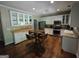 Spacious kitchen featuring an island table, stainless appliances, and plentiful white cabinetry at 57 Deer Creek Run, Moreland, GA 30259