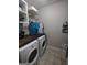 Laundry room with modern washer and dryer, plenty of storage, and tile flooring at 57 Deer Creek Run, Moreland, GA 30259