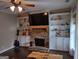 Cozy living room with a stone fireplace, built-in shelving, and dark hardwood floors at 57 Deer Creek Run, Moreland, GA 30259
