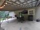Enjoyable outdoor patio with stone flooring, a mounted TV, seating and a grill at 57 Deer Creek Run, Moreland, GA 30259