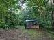 View of a weathered shed in a densely wooded area at 57 Deer Creek Run, Moreland, GA 30259