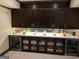 Home bar is equipped with dark cabinets, wine coolers and snacks at 2220 Cambridge Hill Ct, Dacula, GA 30019