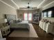 Spacious primary bedroom with a tray ceiling, ceiling fan, and abundant natural light at 2220 Cambridge Hill Ct, Dacula, GA 30019