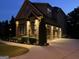 Illuminated two-story brick home featuring a two-car garage, manicured landscaping, and a well-maintained lawn at 2220 Cambridge Hill Ct, Dacula, GA 30019