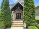 Inviting front entrance with stone facade, wooden door, and professional landscaping creating great curb appeal at 2220 Cambridge Hill Ct, Dacula, GA 30019