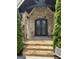 Close up of the front entrance showing stone facade, wooden door, and natural light at 2220 Cambridge Hill Ct, Dacula, GA 30019