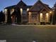 An impressive two-story home exterior with a lush lawn, elegant brickwork, and tasteful landscaping under evening light at 2220 Cambridge Hill Ct, Dacula, GA 30019