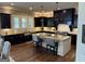 Spacious kitchen with dark cabinets, hardwood floors, stainless steel appliances, and a large center island at 2220 Cambridge Hill Ct, Dacula, GA 30019