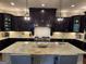 Gourmet kitchen features a large island, stainless appliances, dark wood cabinets and granite countertops at 2220 Cambridge Hill Ct, Dacula, GA 30019