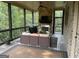 Inviting screened porch with a cozy seating area, a fireplace, and wooded views at 2220 Cambridge Hill Ct, Dacula, GA 30019