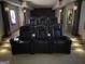 A luxury theater room with leather recliners and sconce lighting at 2220 Cambridge Hill Ct, Dacula, GA 30019