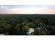 Expansive aerial view showing the home nestled within a lush green canopy, with the city skyline in the distance at 490 Mount Paran Rd, Atlanta, GA 30327