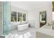 Spa-like bathroom with a soaking tub, marble accents, and plenty of natural light at 490 Mount Paran Rd, Atlanta, GA 30327