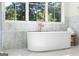 Marble bathroom featuring soaking tub with a window view and modern fixtures at 490 Mount Paran Rd, Atlanta, GA 30327